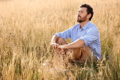Photo of Man enjoying feeling of freedom on reed grass meadow