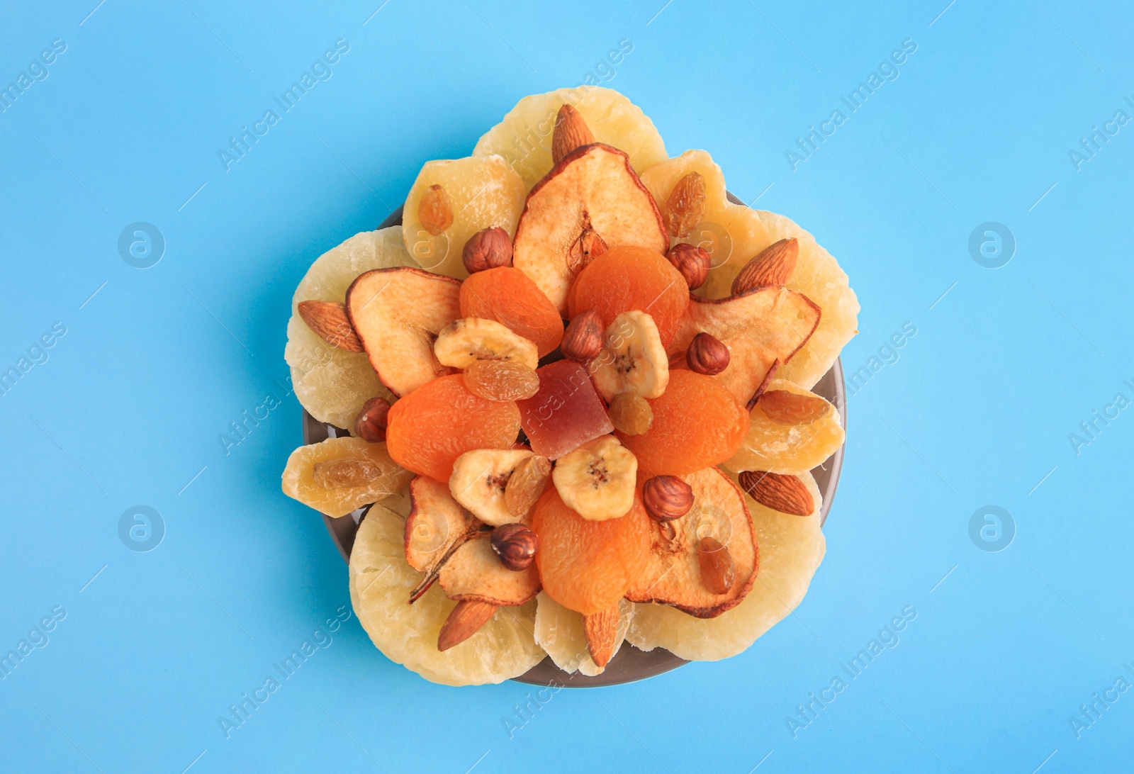 Photo of Mixed dried fruits and nuts on light blue background, top view