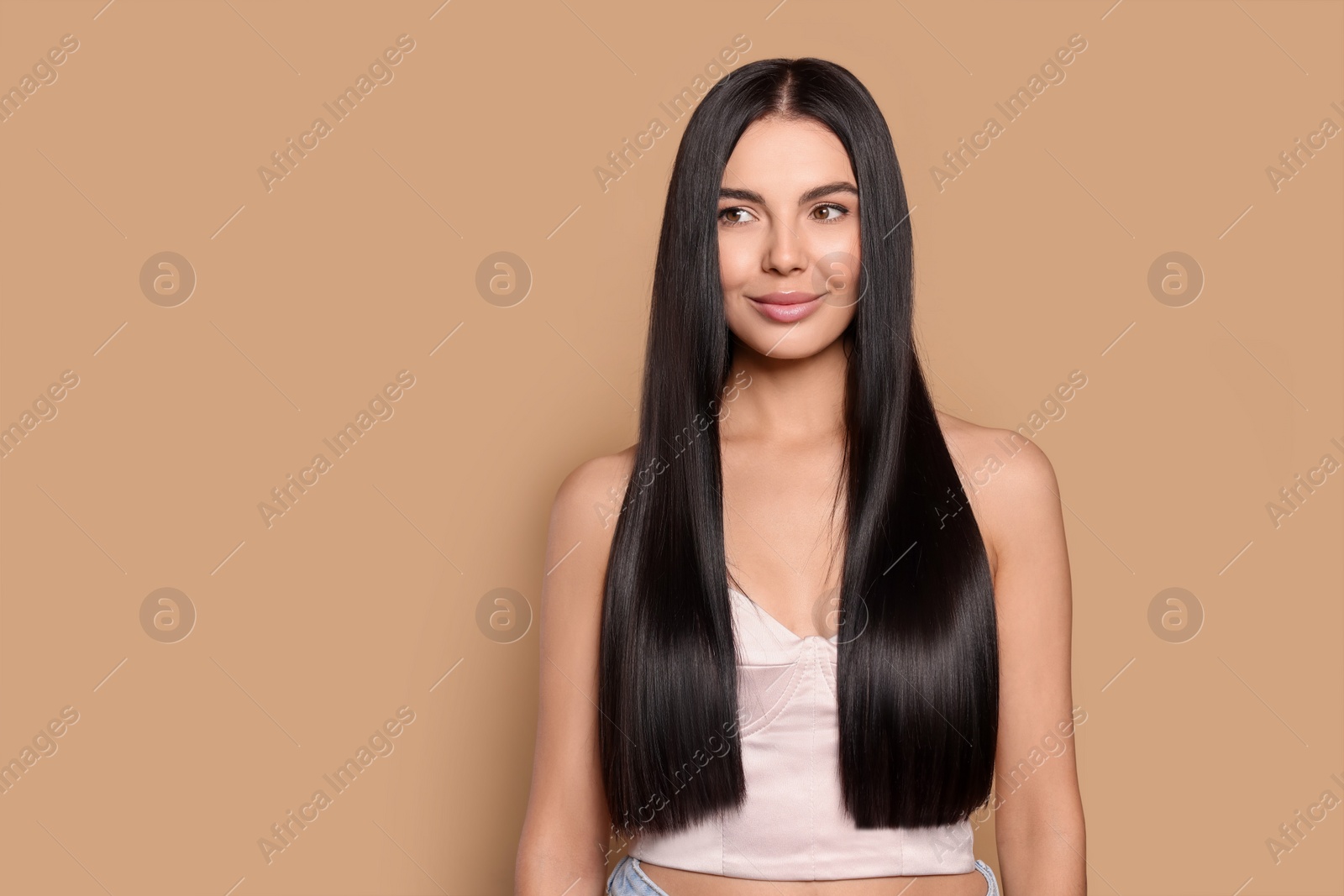 Photo of Portrait of beautiful young woman with healthy strong hair on beige background, space for text