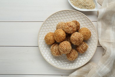 Photo of Delicious sesame balls on white wooden table, flat lay. Space for text