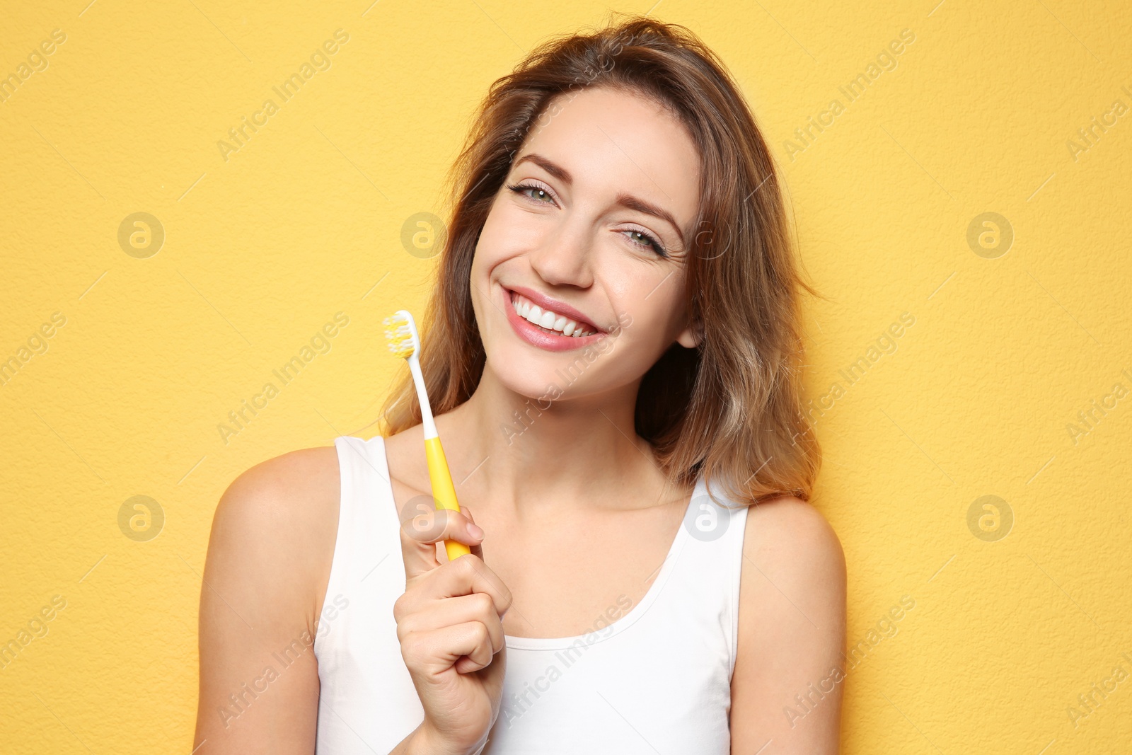 Photo of Portrait of young woman with toothbrush on color background