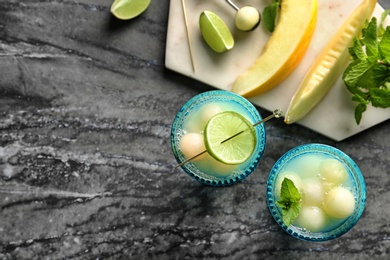 Photo of Melon ball cocktail served on black marble table, flat lay. Space for text