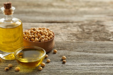 Photo of Composition with soybean oil on wooden table. Space for text