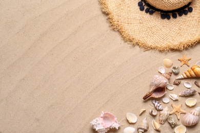 Photo of Straw hat, starfishes and seashells on beach sand, flat lay with space for text. Summer vacation