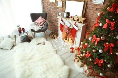 Photo of Room interior with beautiful Christmas tree and gifts near decorative fireplace