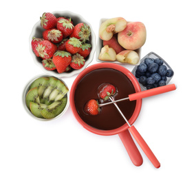 Fondue pot with chocolate and mix of fruits on white background, top view