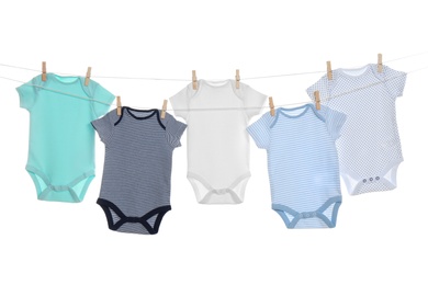 Colorful baby onesies hanging on clothes line against white background. Laundry day