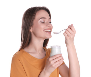 Young attractive woman eating tasty yogurt on white background