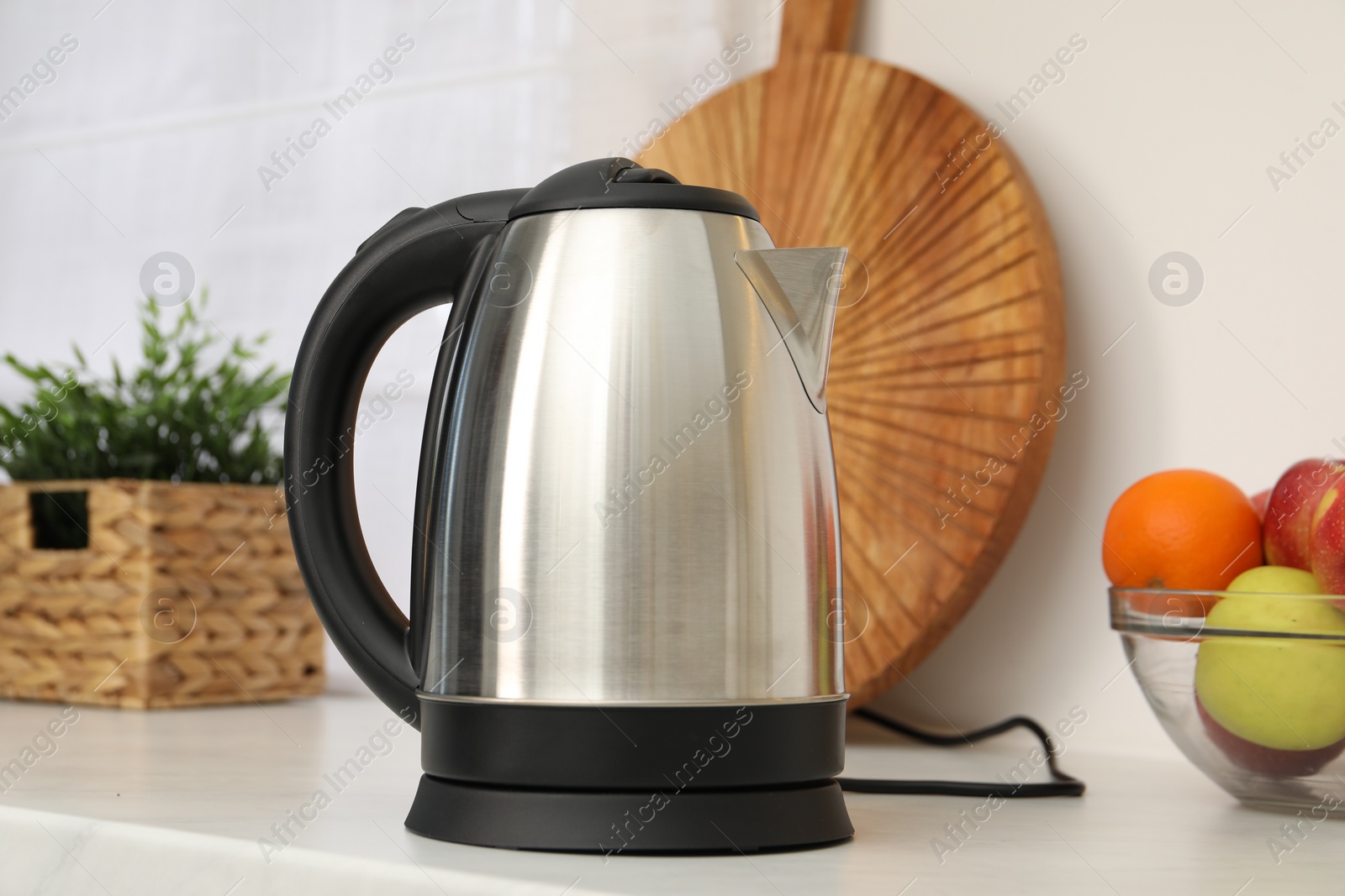 Photo of Modern electric kettle on counter in kitchen