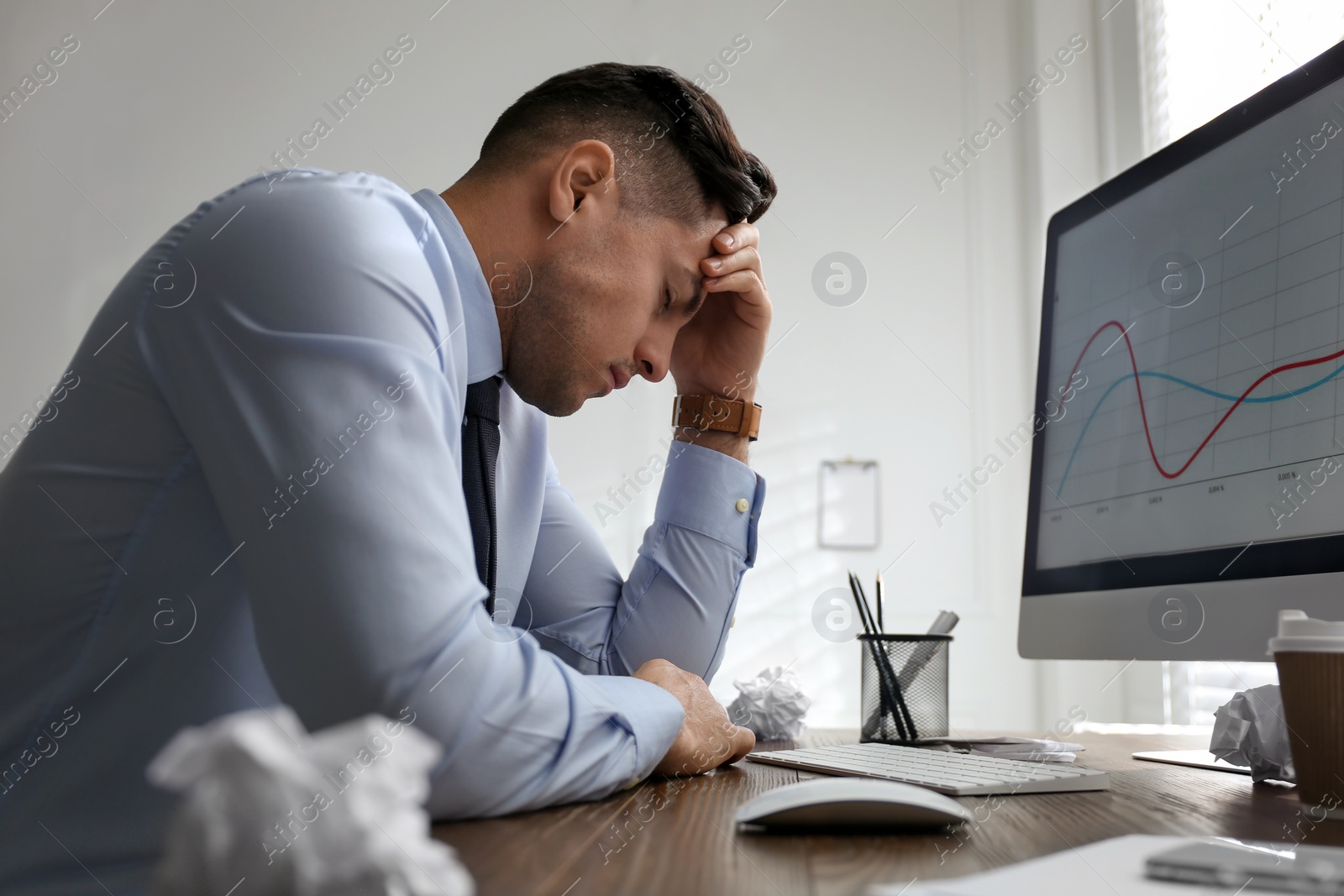 Photo of Businessman stressing out at workplace in office