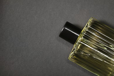 Photo of Luxury men`s perfume in bottle on black background, top view. Space for text