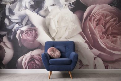 Photo of Comfortable armchair near wall with floral wallpaper. Stylish living room interior