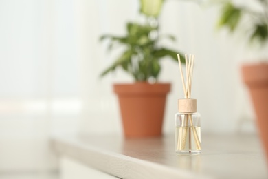 Photo of Reed air freshener on table indoors, space for text