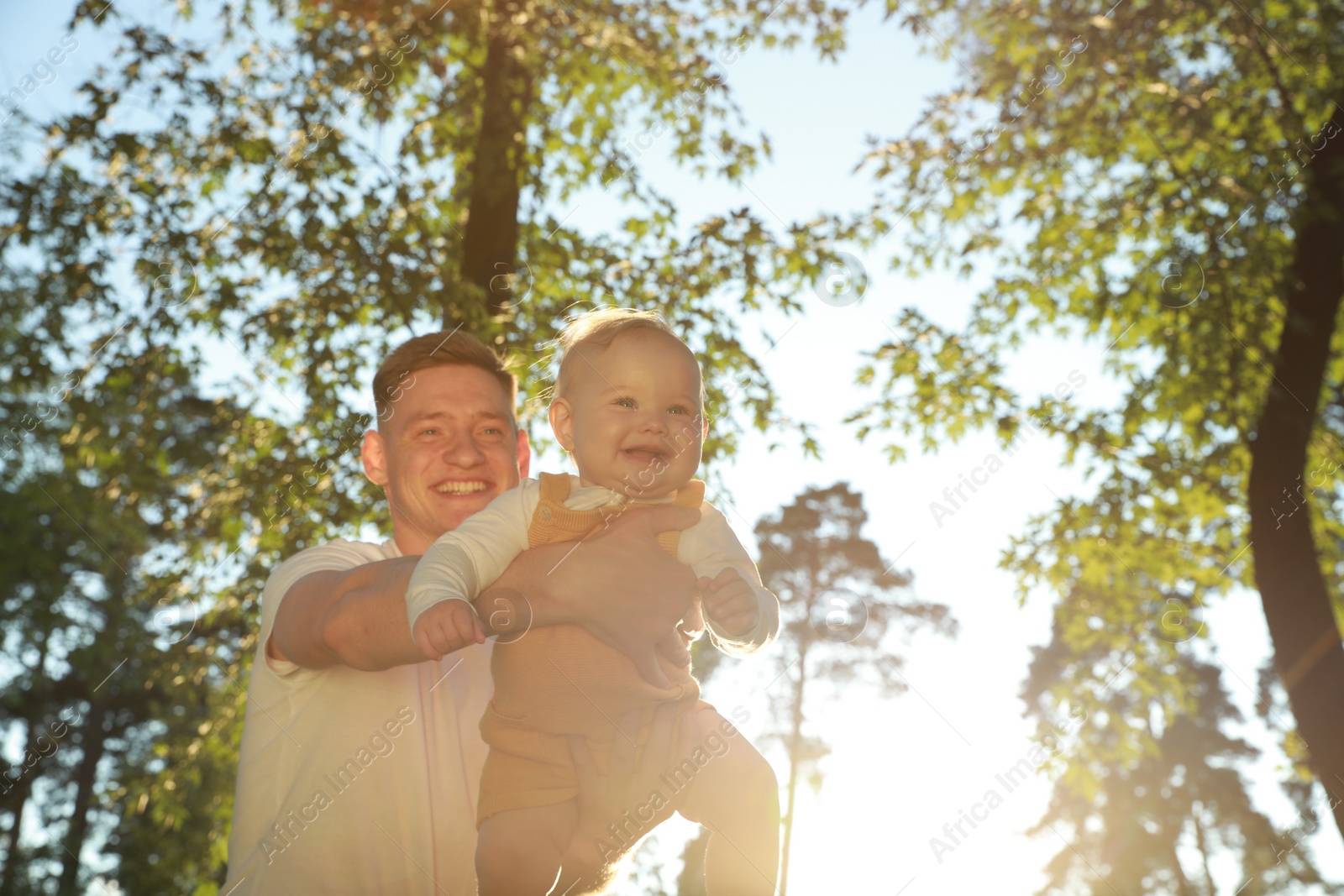 Photo of Father with his cute daughter spending time together in park on summer day, space for text