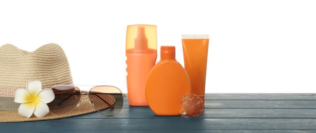 Sun protection products and beach accessories on blue wooden table