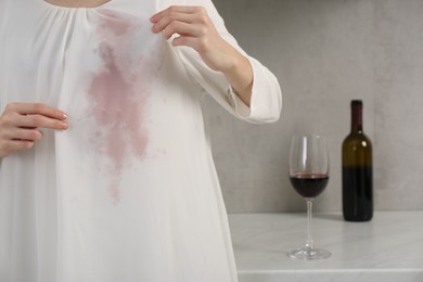 Photo of Woman with wine stain on her clothes indoors, closeup. Space for text