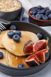 Photo of Tasty oatmeal pancakes on white table, closeup