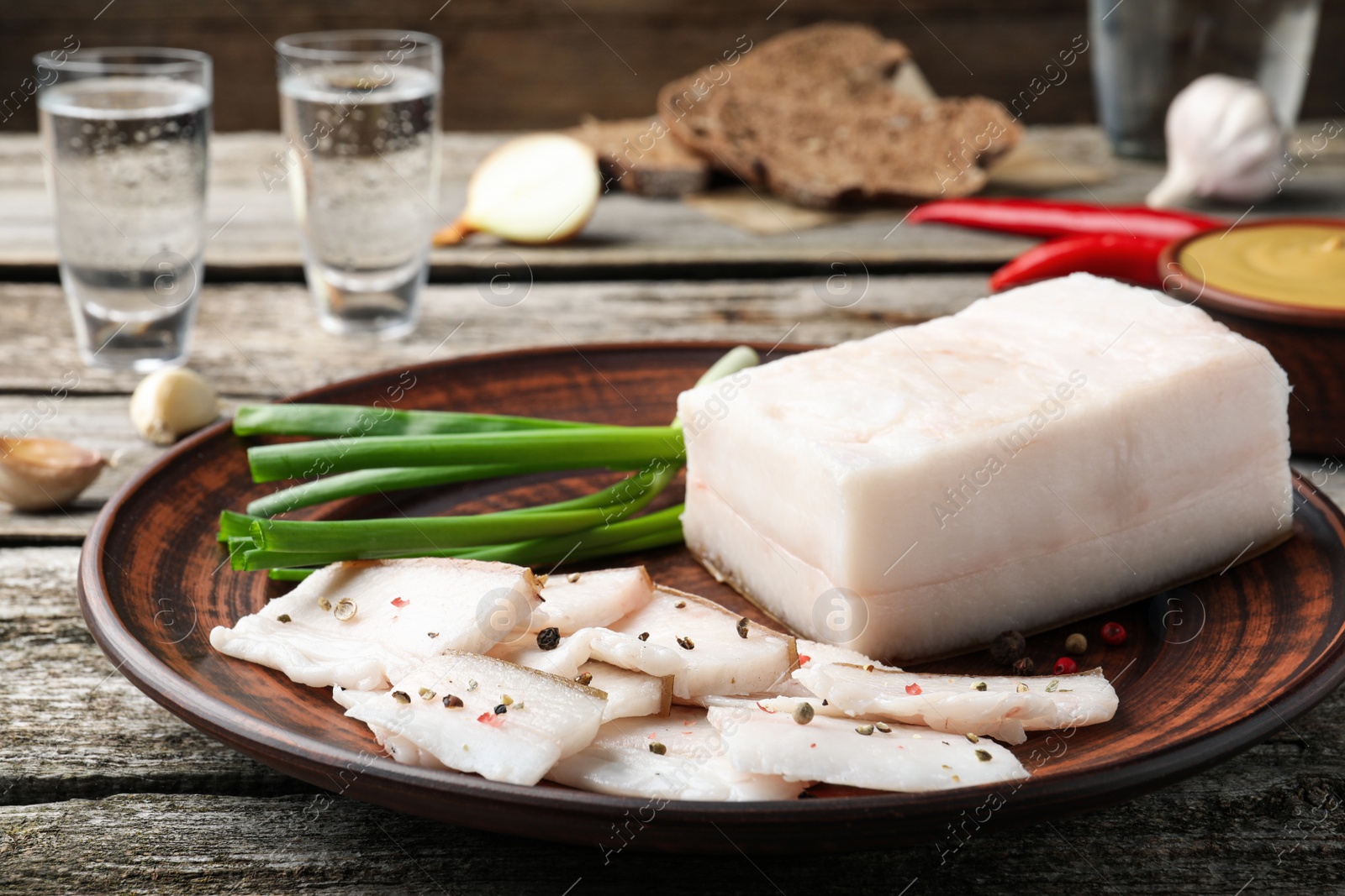 Photo of Tasty salt pork with green onion served on wooden table