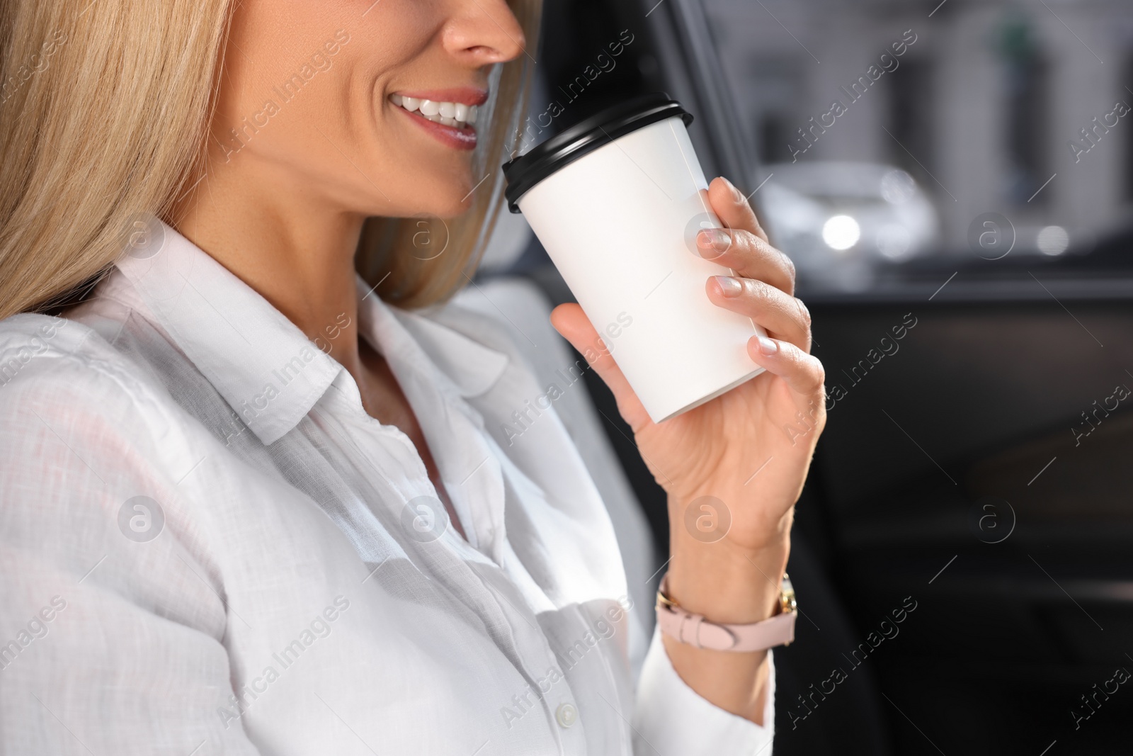 Photo of To-go drink. Woman drinking coffee in car, closeup