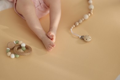 Photo of Cute baby and rattle toys on beige background, closeup. Space for text