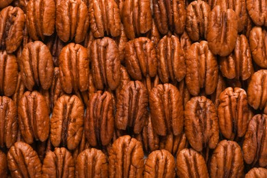 Photo of Tasty fresh ripe pecan nuts as background, top view