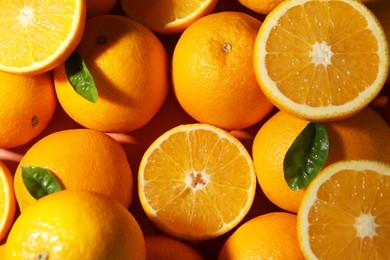 Photo of Tasty ripe fresh oranges and leaves as background, top view