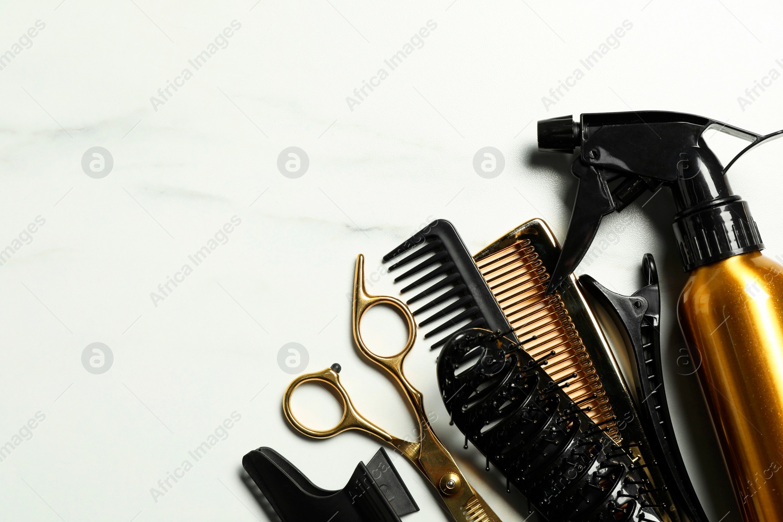 Photo of Hairdressing tools on white marble table, flat lay. Space for text