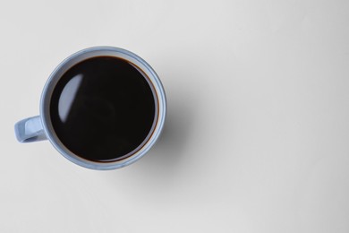 Photo of Mug of freshly brewed hot coffee on white background, top view. Space for text