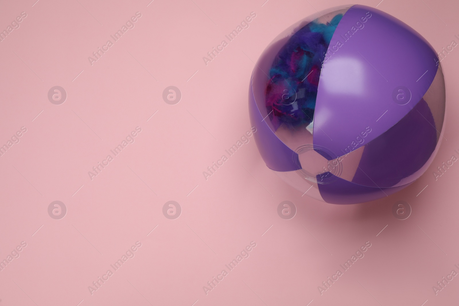 Photo of Colorful beach ball on pink background, top view. Space for text