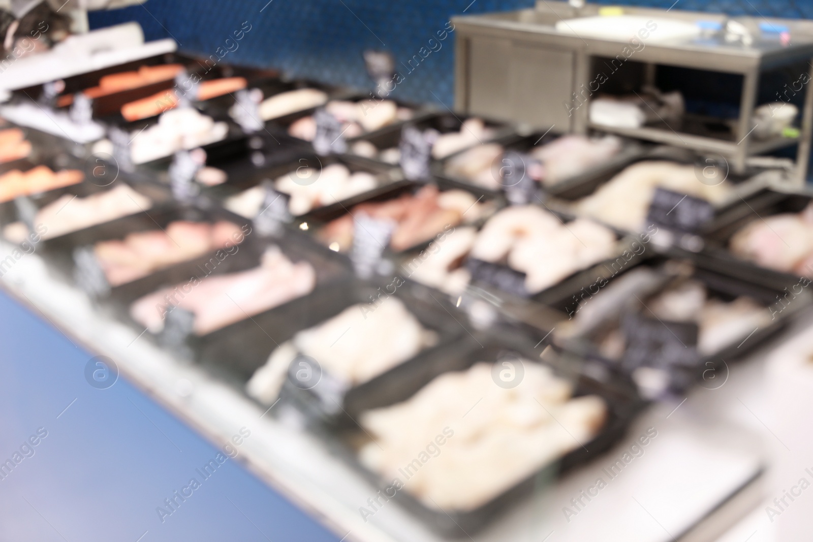 Photo of Blurred view of showcase with different seafood in store. Wholesale market