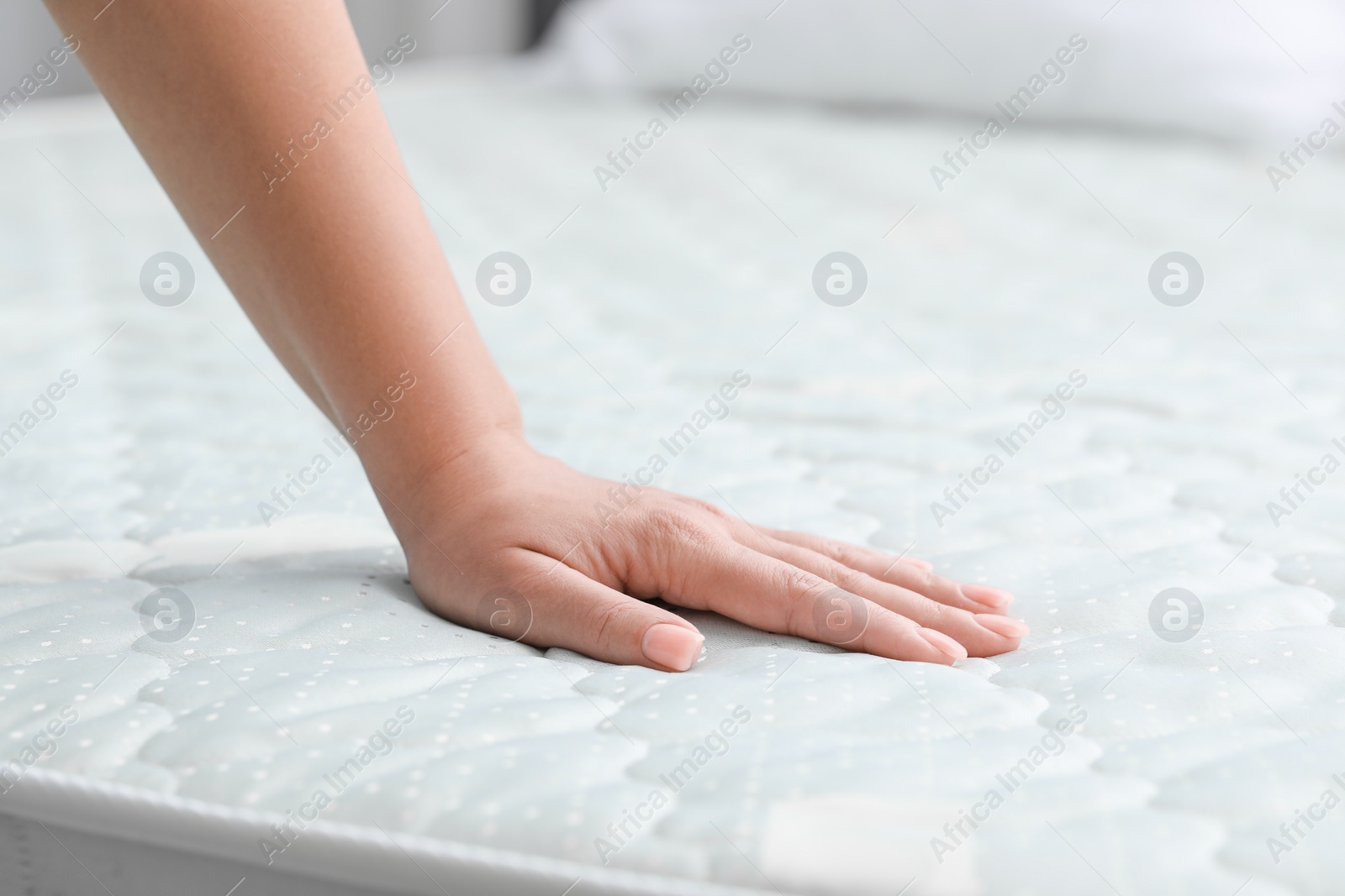 Photo of Woman touching new soft mattress, closeup view