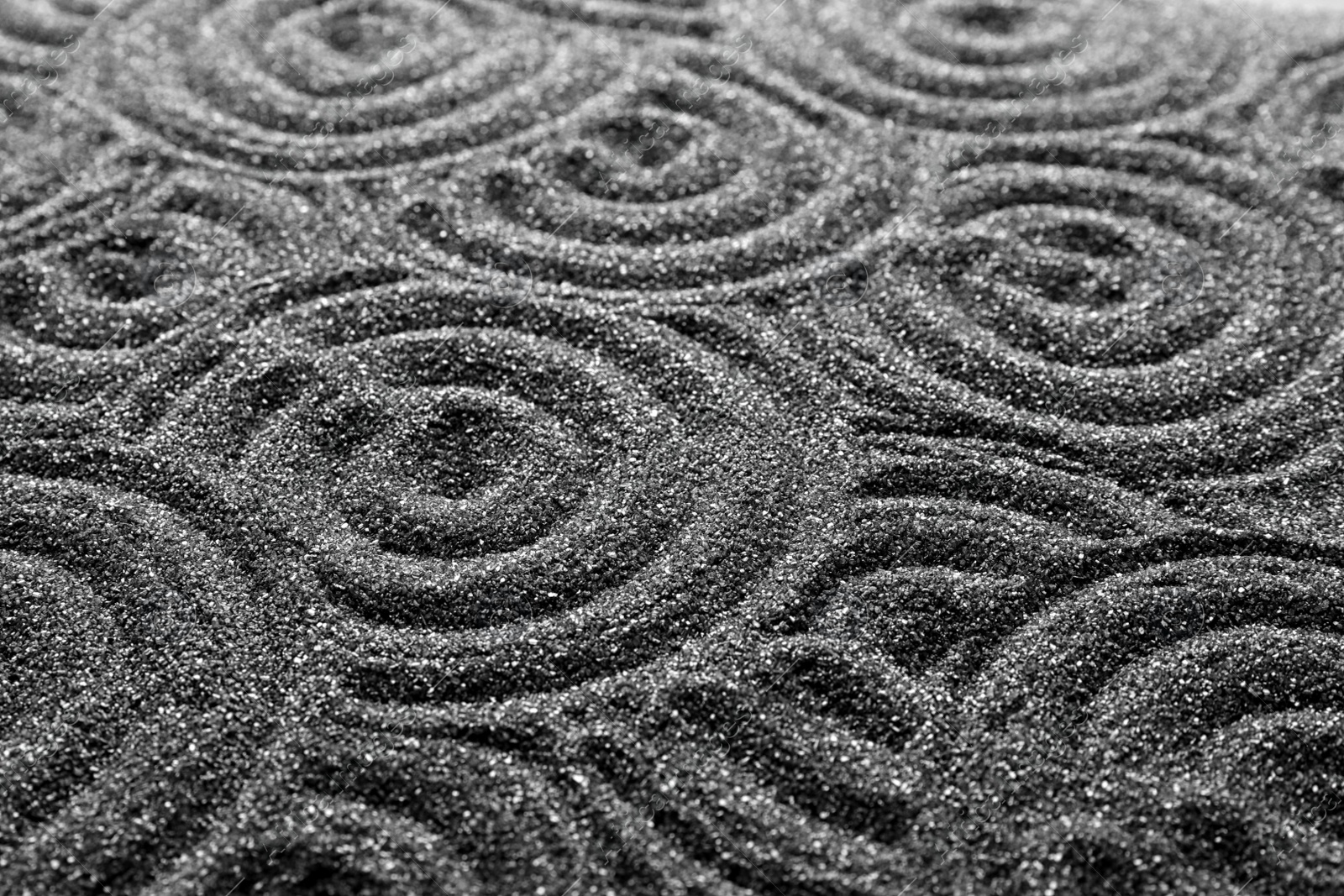 Photo of Pattern on decorative black sand, closeup. Zen and harmony