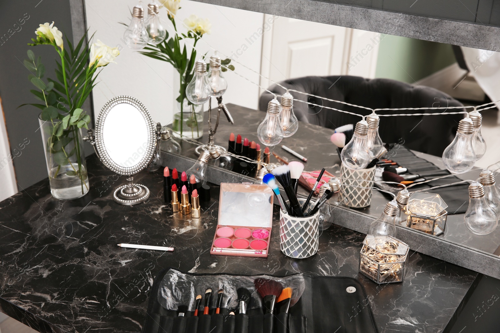 Photo of Decorative cosmetics and tools on dressing table in makeup room