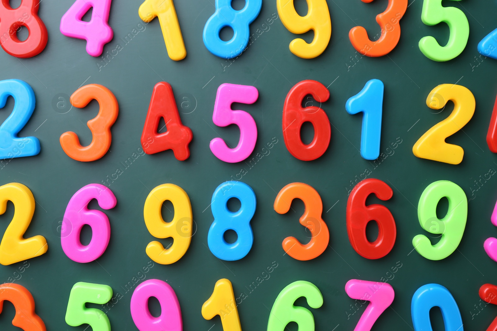 Photo of Colorful numbers on green background, flat lay