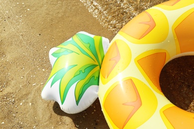 Photo of Bright inflatable pineapple ring near sea on sunny day, closeup. Space for text