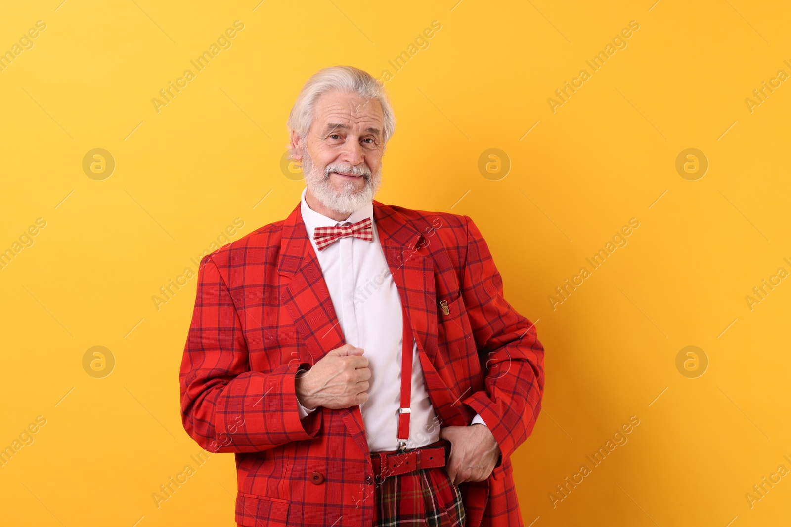 Photo of Portrait of grandpa with stylish red suit and bowtie on yellow background