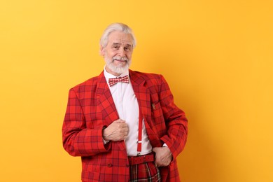 Photo of Portrait of grandpa with stylish red suit and bowtie on yellow background