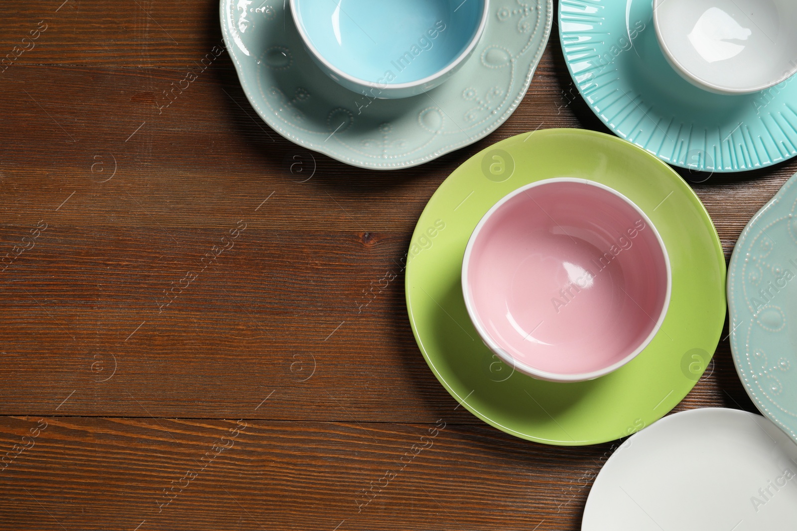 Photo of Beautiful ceramic dishware on wooden table, flat lay. Space for text