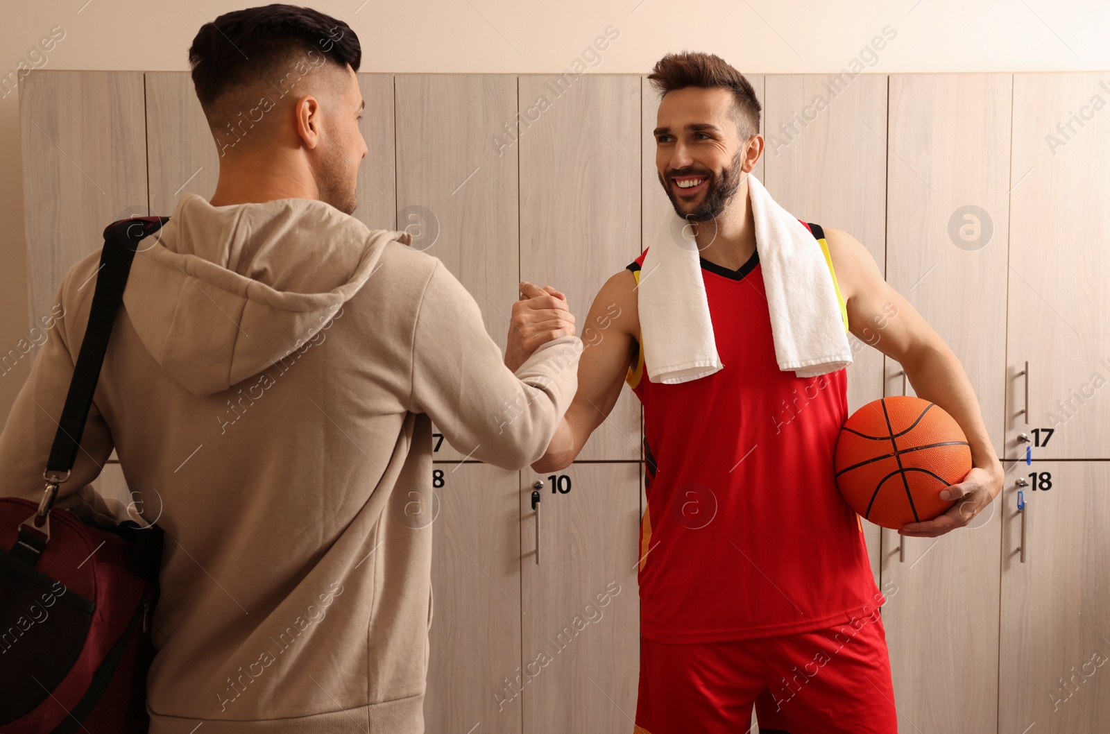 Photo of Handsome men greeting each other in locker room