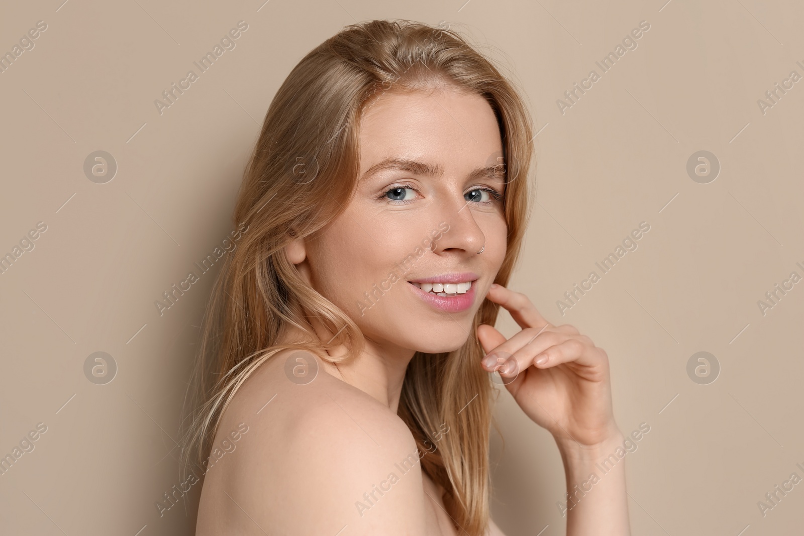 Photo of Portrait of beautiful young woman on beige background