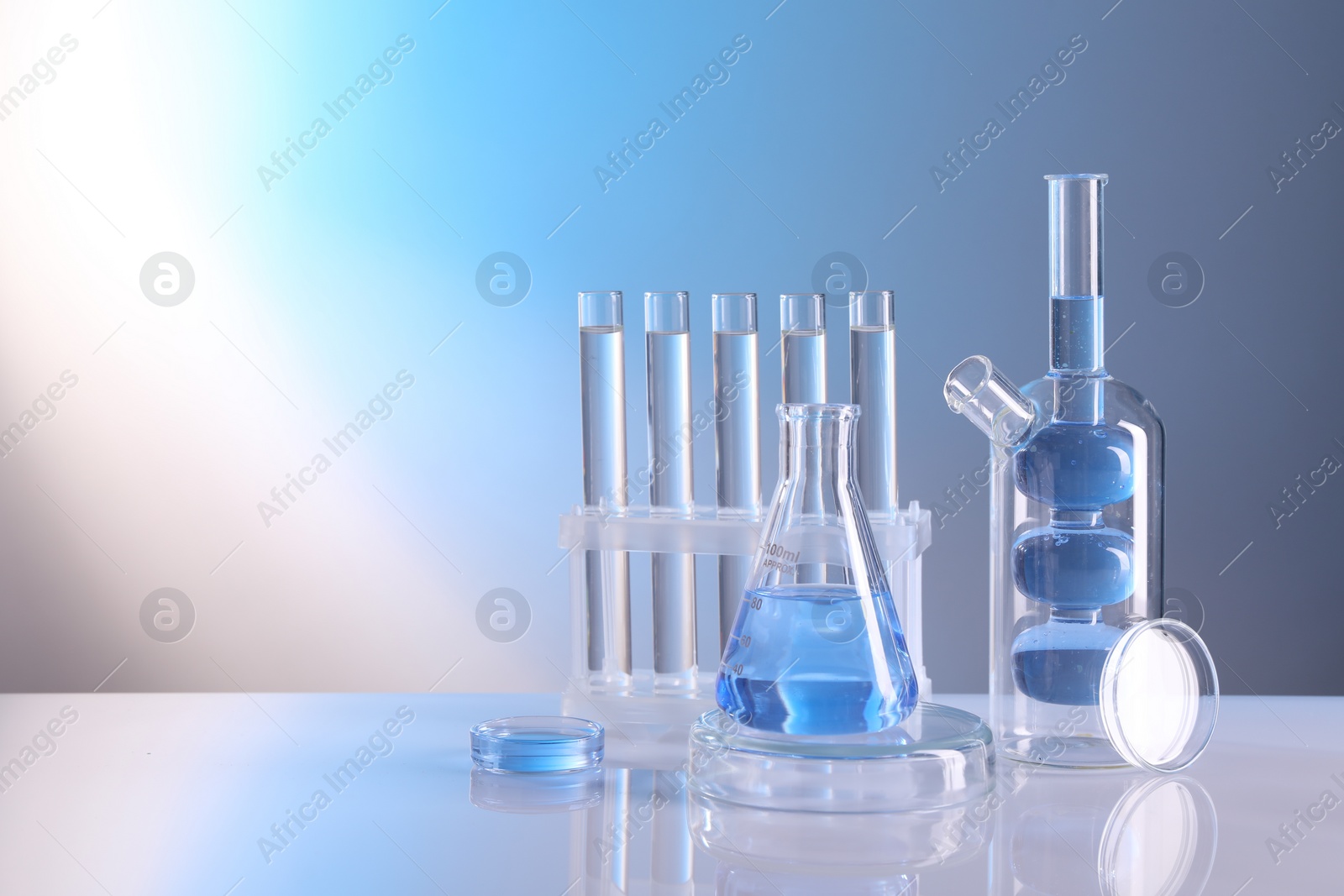 Photo of Laboratory analysis. Different glassware on table against light background, space for text