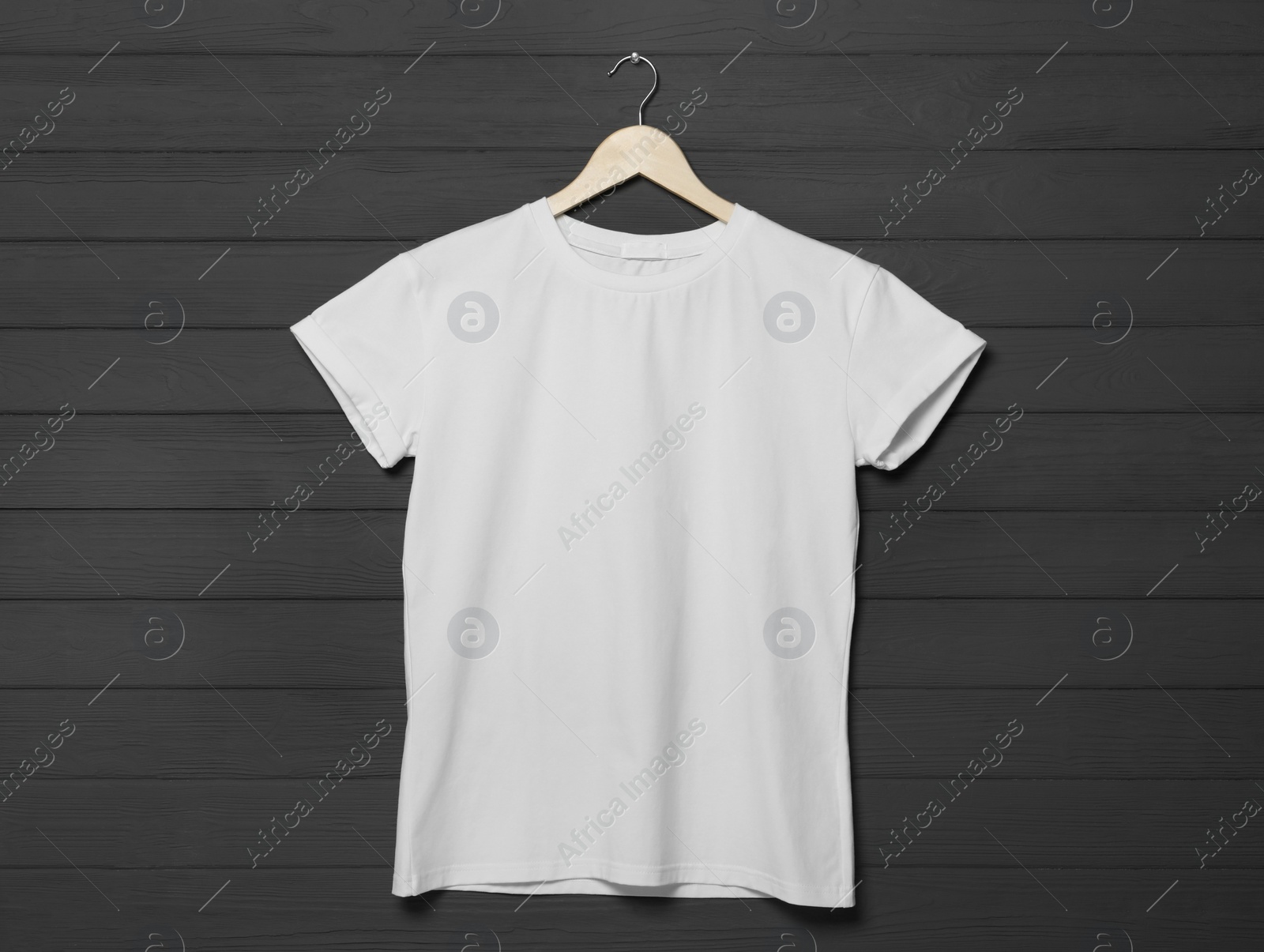 Photo of Hanger with stylish white T-shirt on gray wooden wall