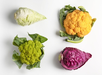 Photo of Different fresh cabbages on white background, top view. Healthy food