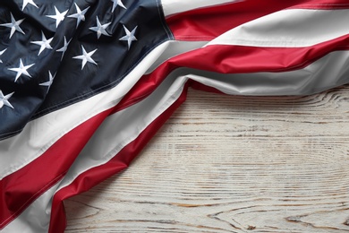 American flag on white wooden background, top view with space for text