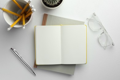 Photo of Flat lay composition with notebooks and pen on white table. Space for text