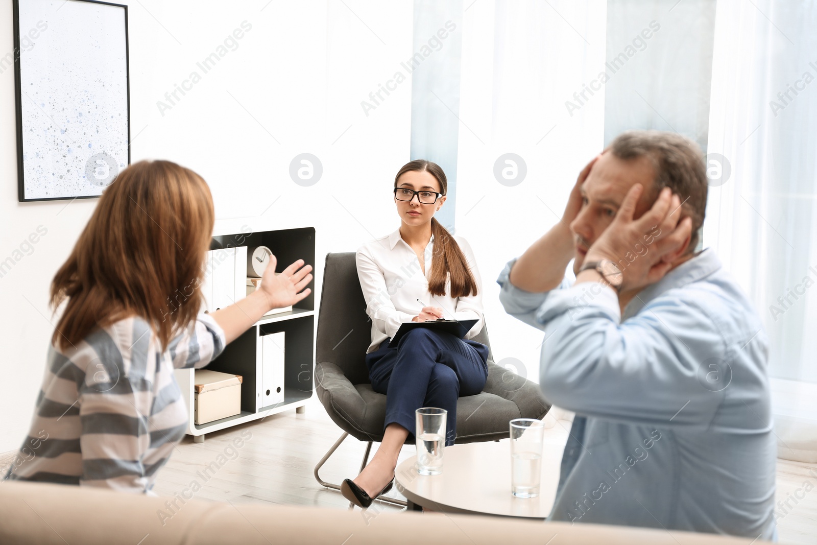 Photo of Psychotherapist working with couple in office. Family counselling