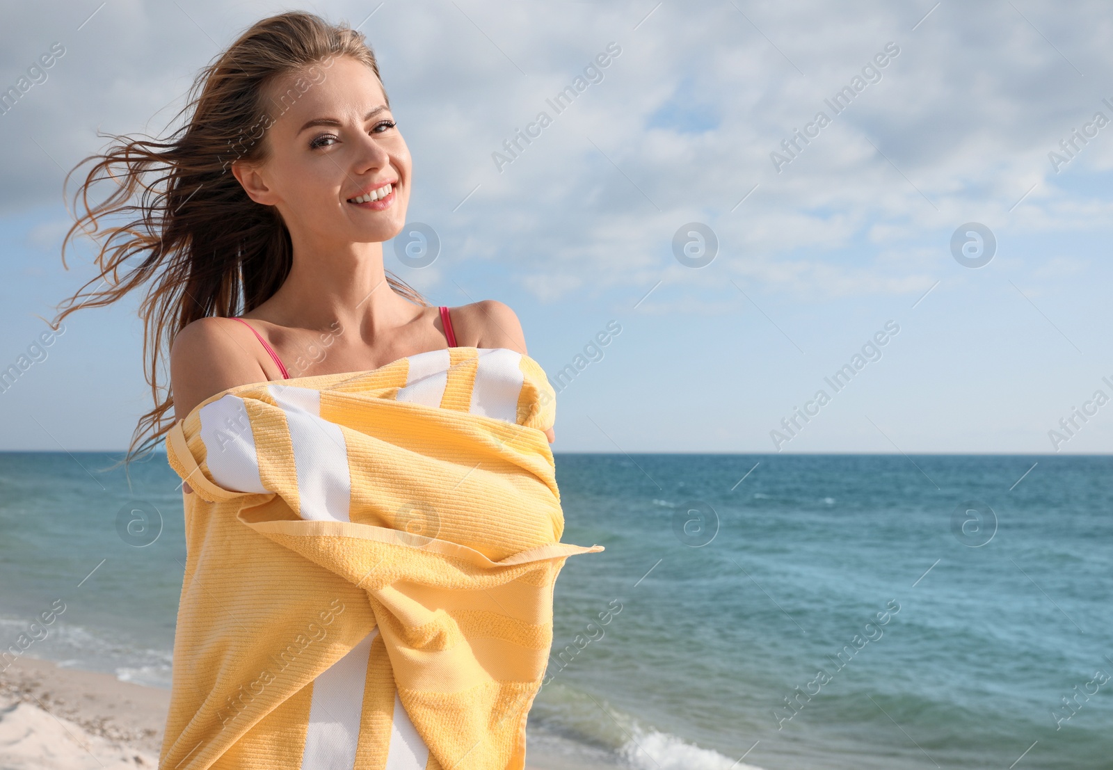 Photo of Beautiful woman with bright beach towel near sea