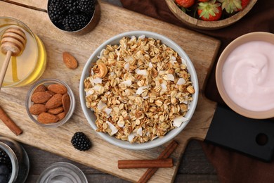 Photo of Tasty granola, yogurt and fresh berries served on wooden table, flat lay. Healthy breakfast