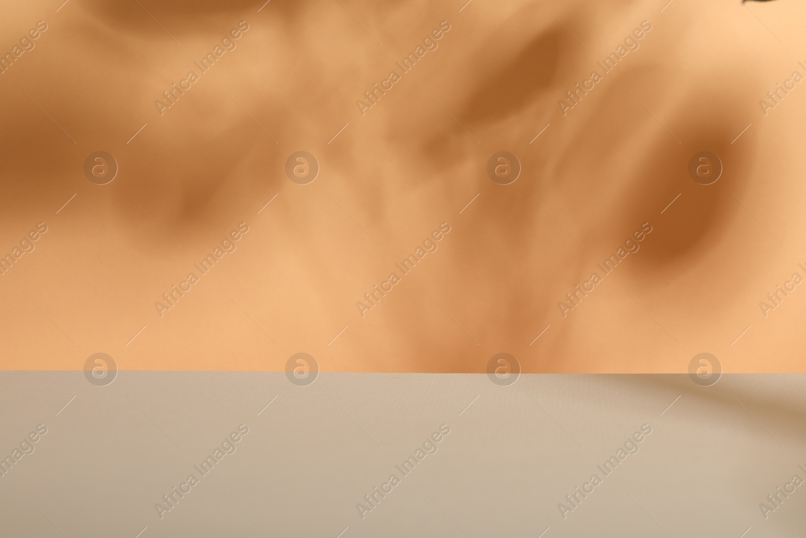 Photo of Presentation of product. Shadows on orange background. Space for text