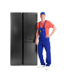 Photo of Male technician near refrigerator on white background